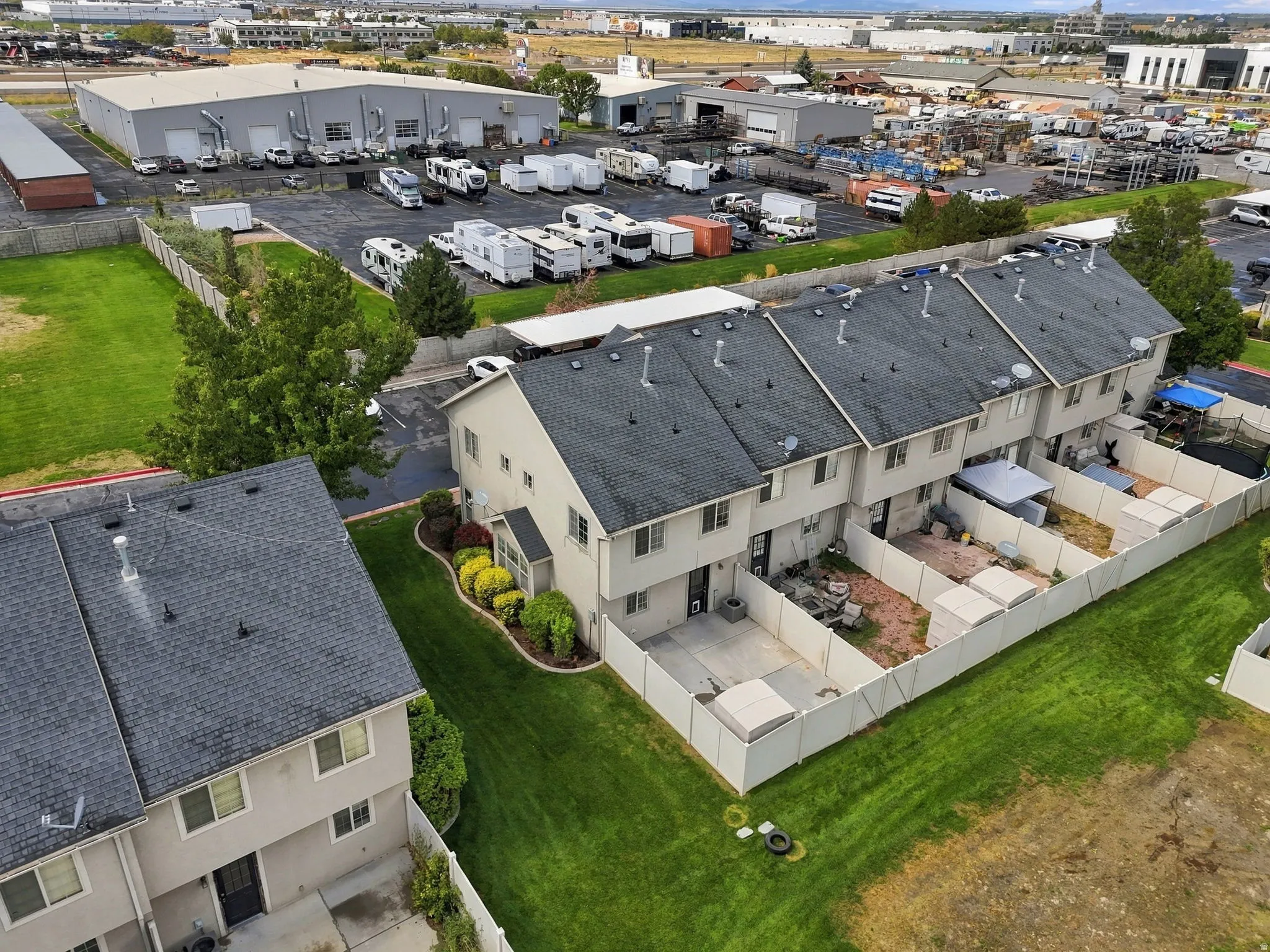 Townhome-style residences featuring asphalt shingle roofs and individual fenced outdoor spaces
