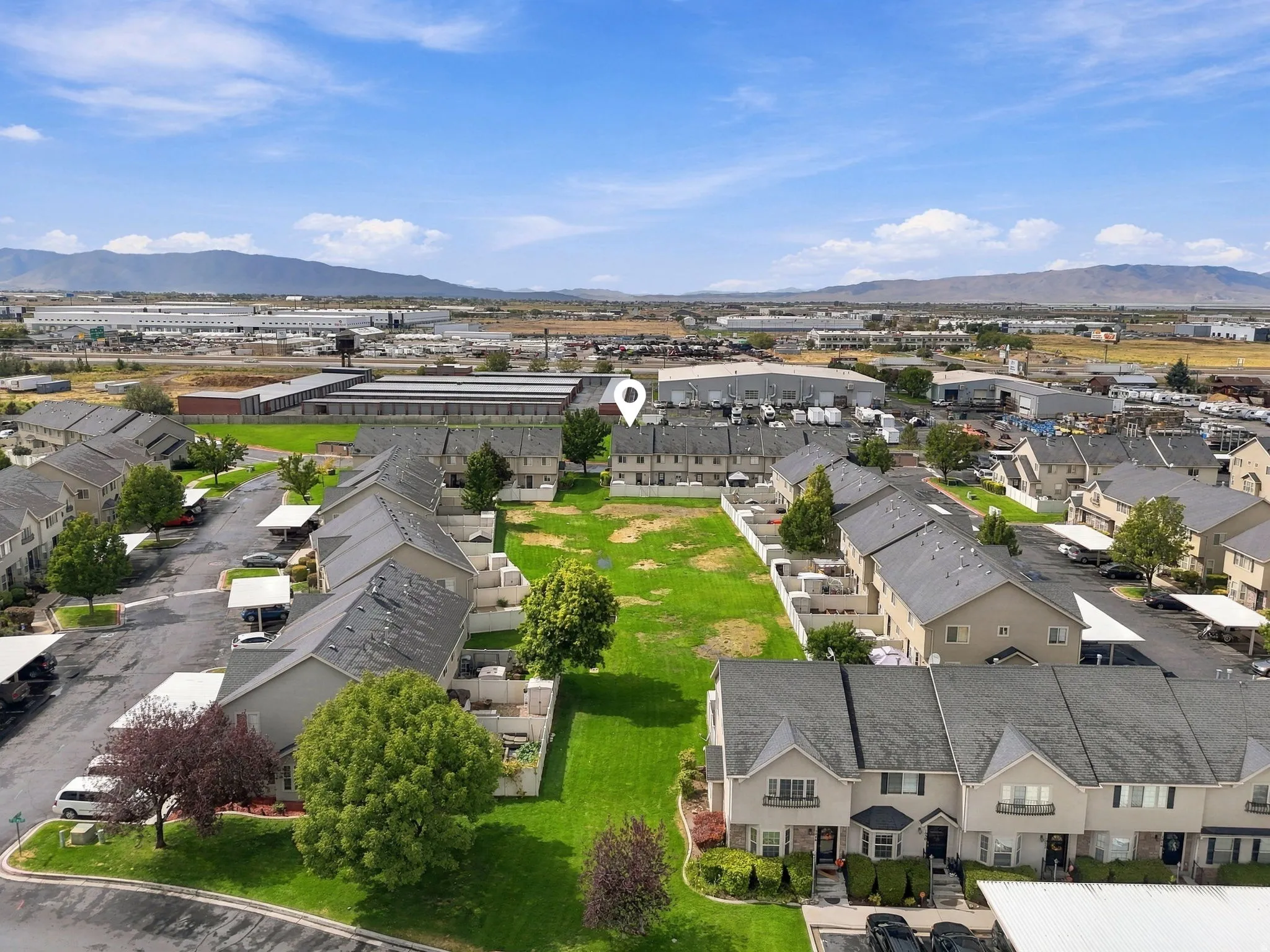 Townhome community featuring covered parking, mature trees, and mountain scenery