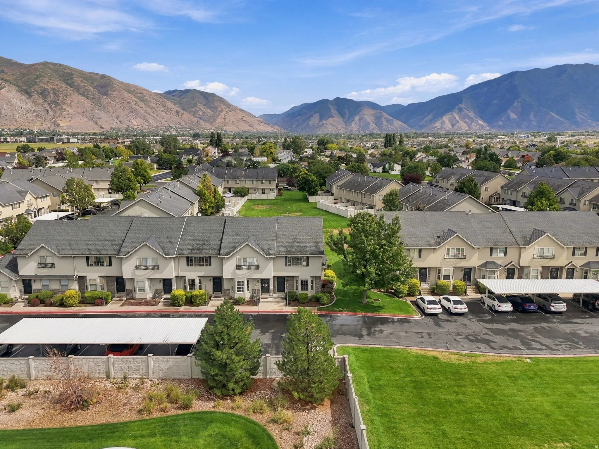 Mountain backdrop, developed neighborhood, townhome properties, covered parking, manicured green spaces