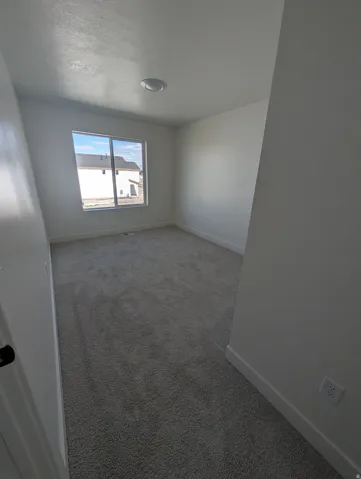 Neutral wall finishes, recessed lighting, and a window with a white frame