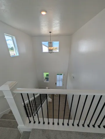 Two-story foyer with recessed lighting, a decorative chandelier, and an entryway door featuring a window panel