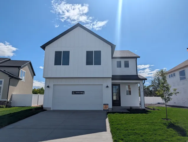 Contemporary exterior with vertical and horizontal siding, an attached garage, a covered entry, and a manicured lawn