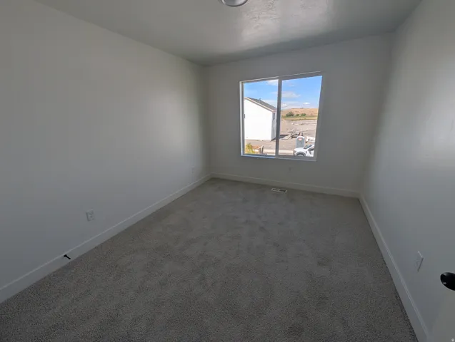 Recessed ceiling light, neutral wall paint, carpeted flooring, and a large window