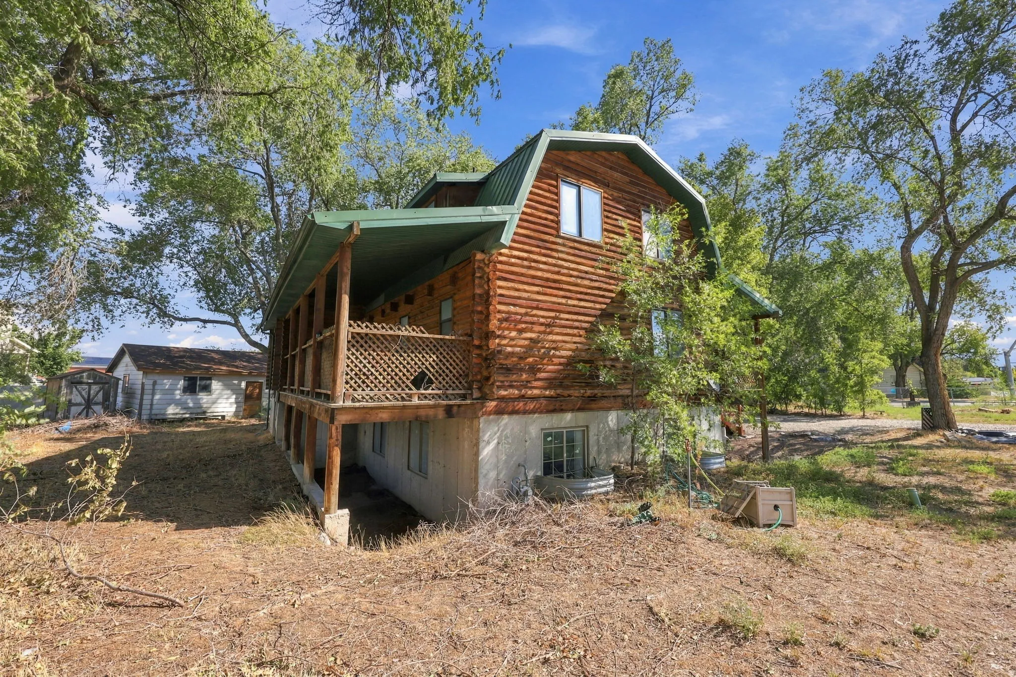 Barn-style home featuring wood siding, a green metal roof, and an expansive covered balcony