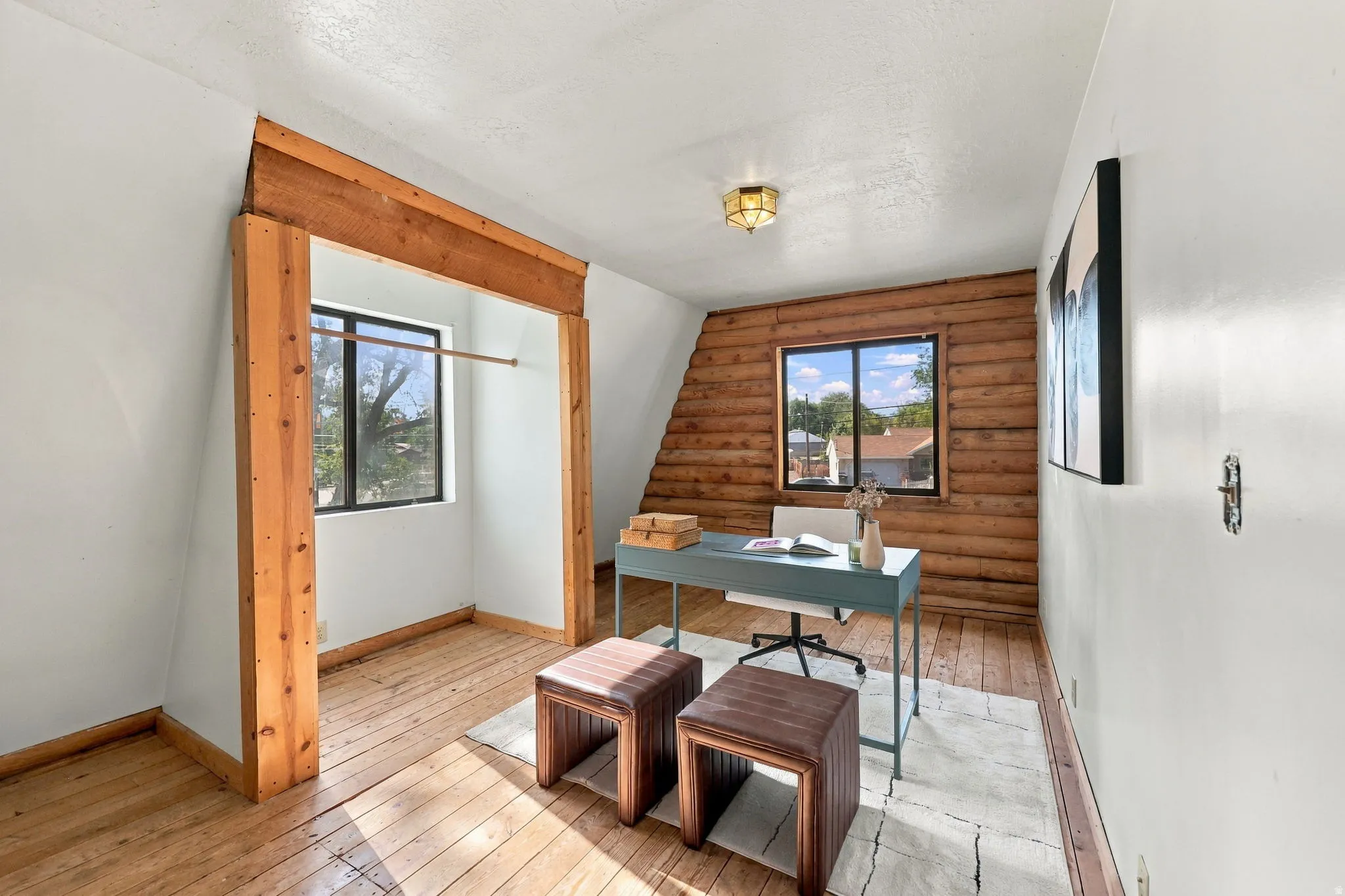 Wood-finish flooring with a sloped ceiling and recessed window