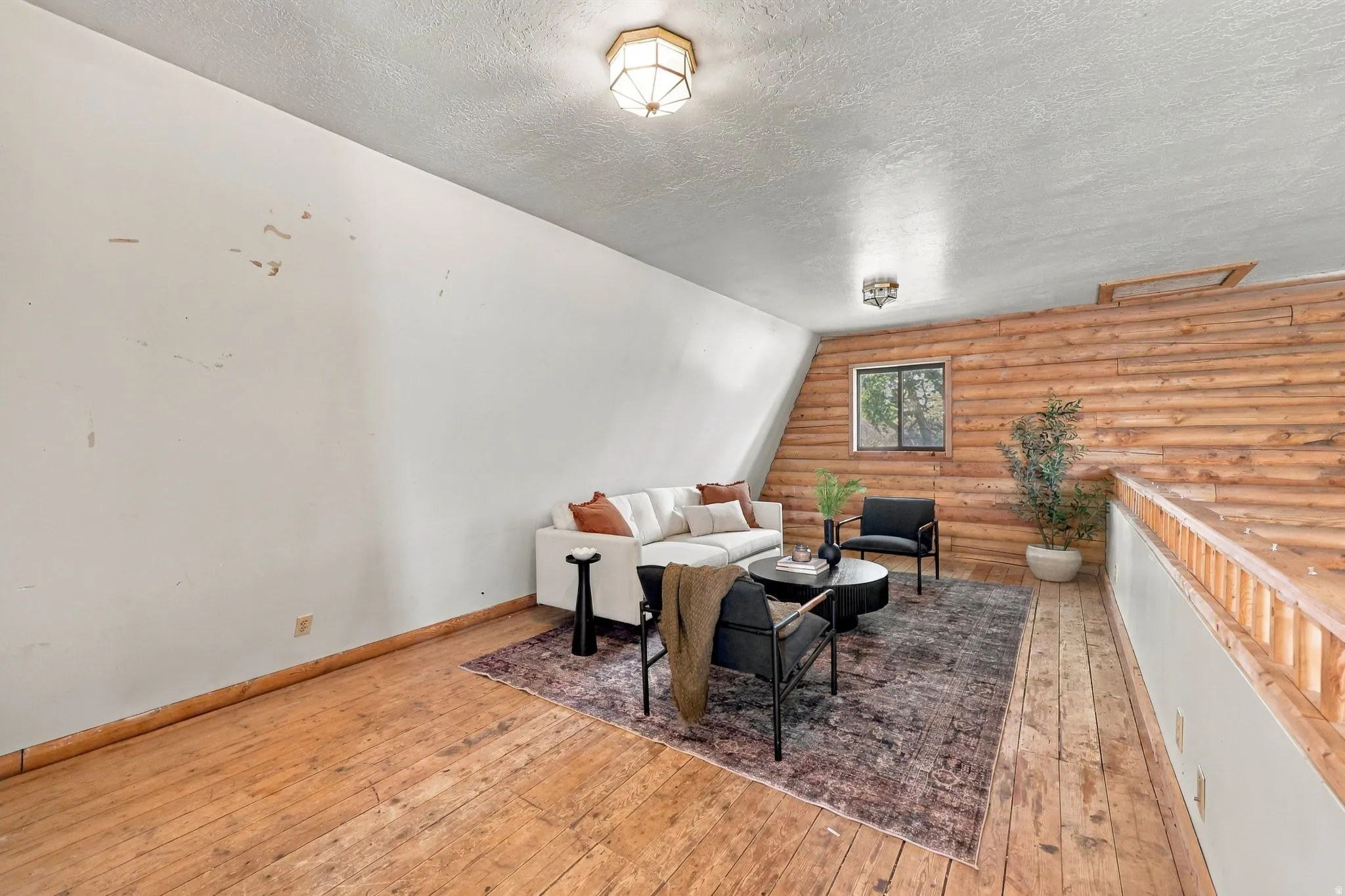 Wood-finish flooring, wood plank accent wall, sloped ceiling, and overhead lighting