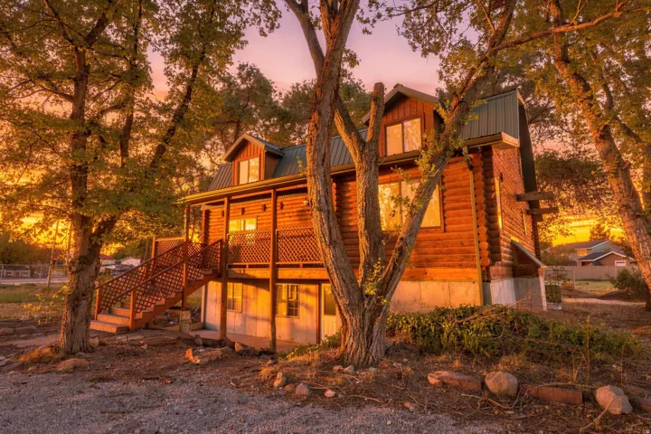 Log-sided residence featuring a metal roof and an elevated porch