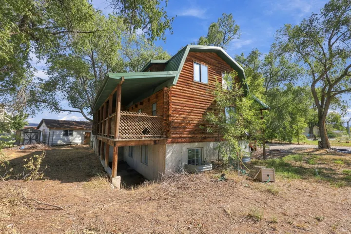 Barn-style home featuring wood siding, a green metal roof, and an expansive covered balcony