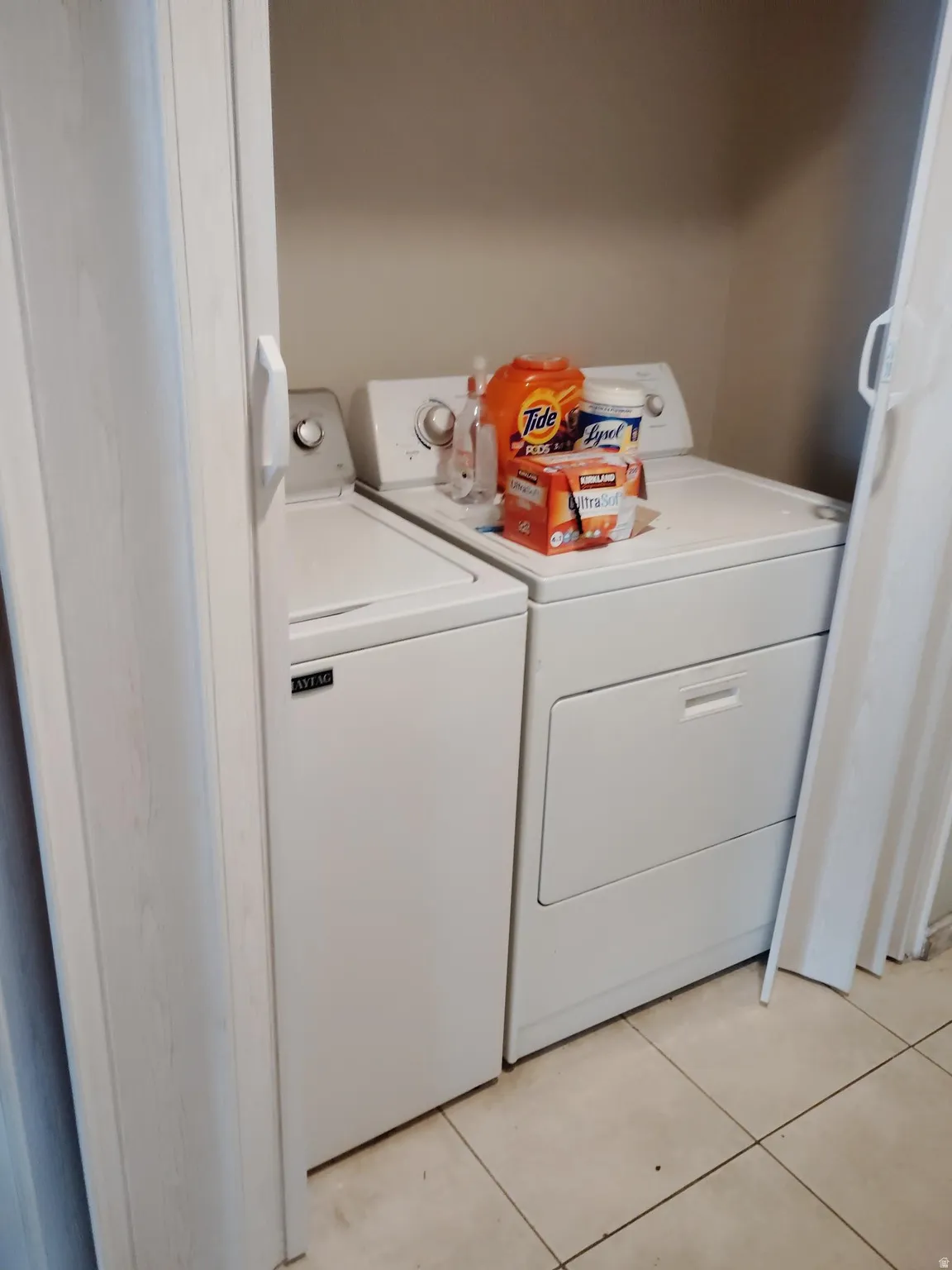 Dedicated laundry area with tile flooring and double bifold doors