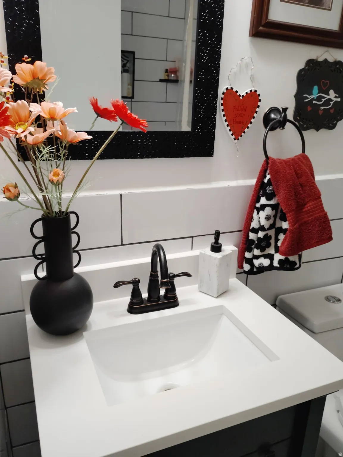 White countertop with an integrated sink, bronze-finish faucet, and subway tile backsplash
