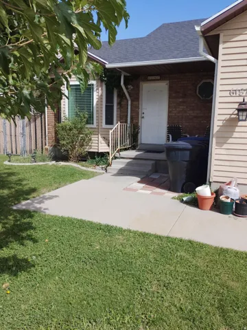 Brick and siding exterior with a shingled roof, featuring a concrete walkway and front steps