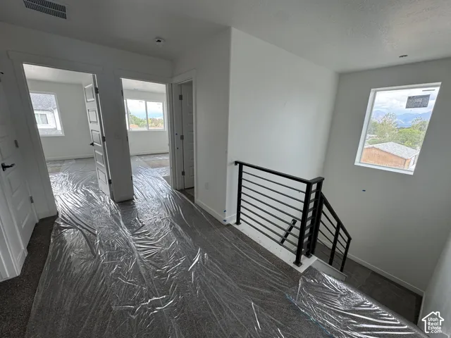 Contemporary horizontal metal railing, white walls, and multiple windows