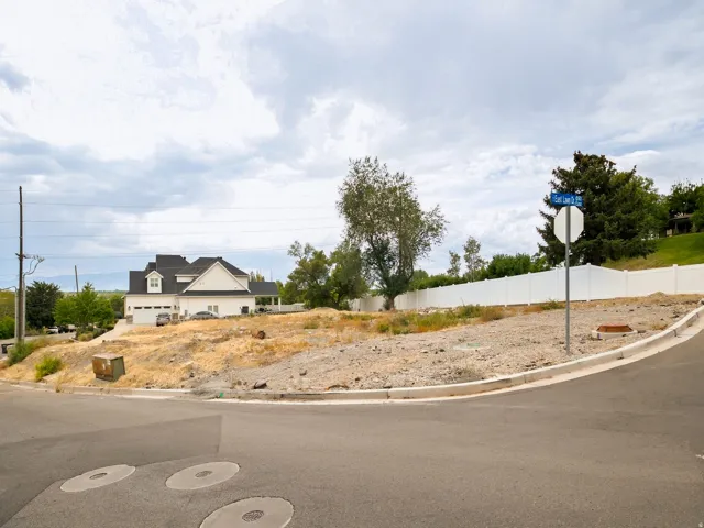 Corner lot with partial white privacy fencing and established street signage