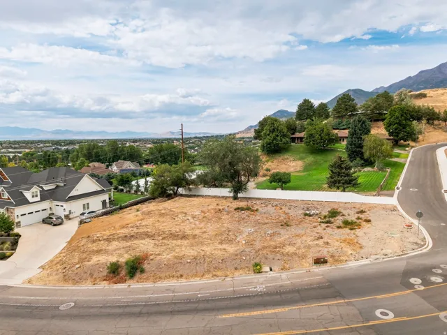 Expansive undeveloped lot with partial fencing and mountain backdrop