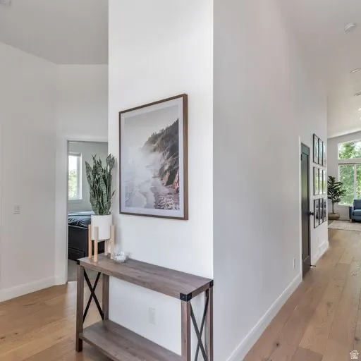 Vaulted ceilings, light wood-finish flooring, and white walls create a bright interior