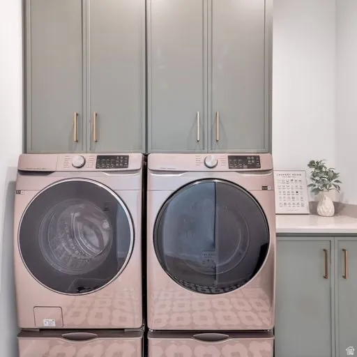 Integrated washer and dryer units, built-in cabinetry with gold-tone hardware, and a countertop surface