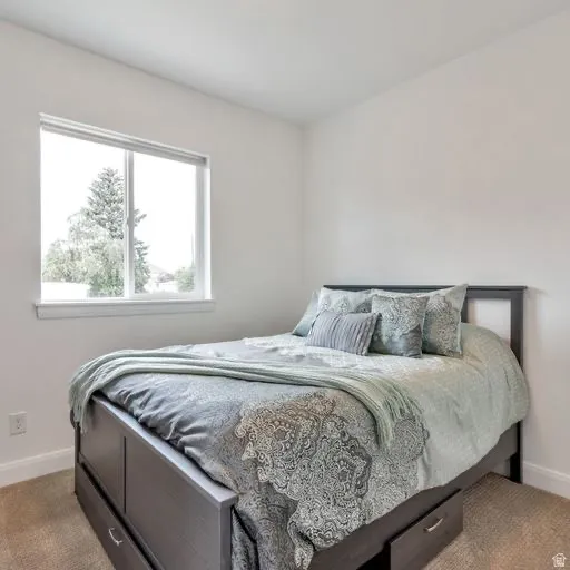Recessed window with white trim, light neutral wall paint, and light-tone carpet flooring