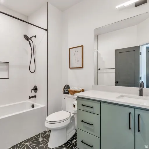 Modern bathroom featuring a white bathtub/shower combination with black fixtures, a patterned floor, and a vanity with a white countertop