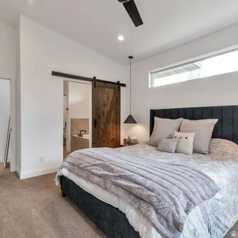 Recessed ceiling lighting, ceiling fan, carpet flooring, transom window, and a wood-finish barn door