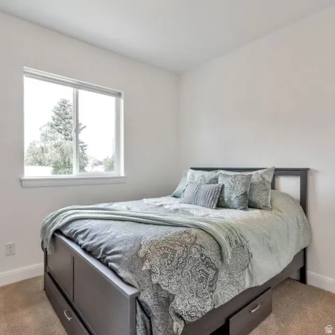 Recessed window with white trim, light neutral wall paint, and light-tone carpet flooring