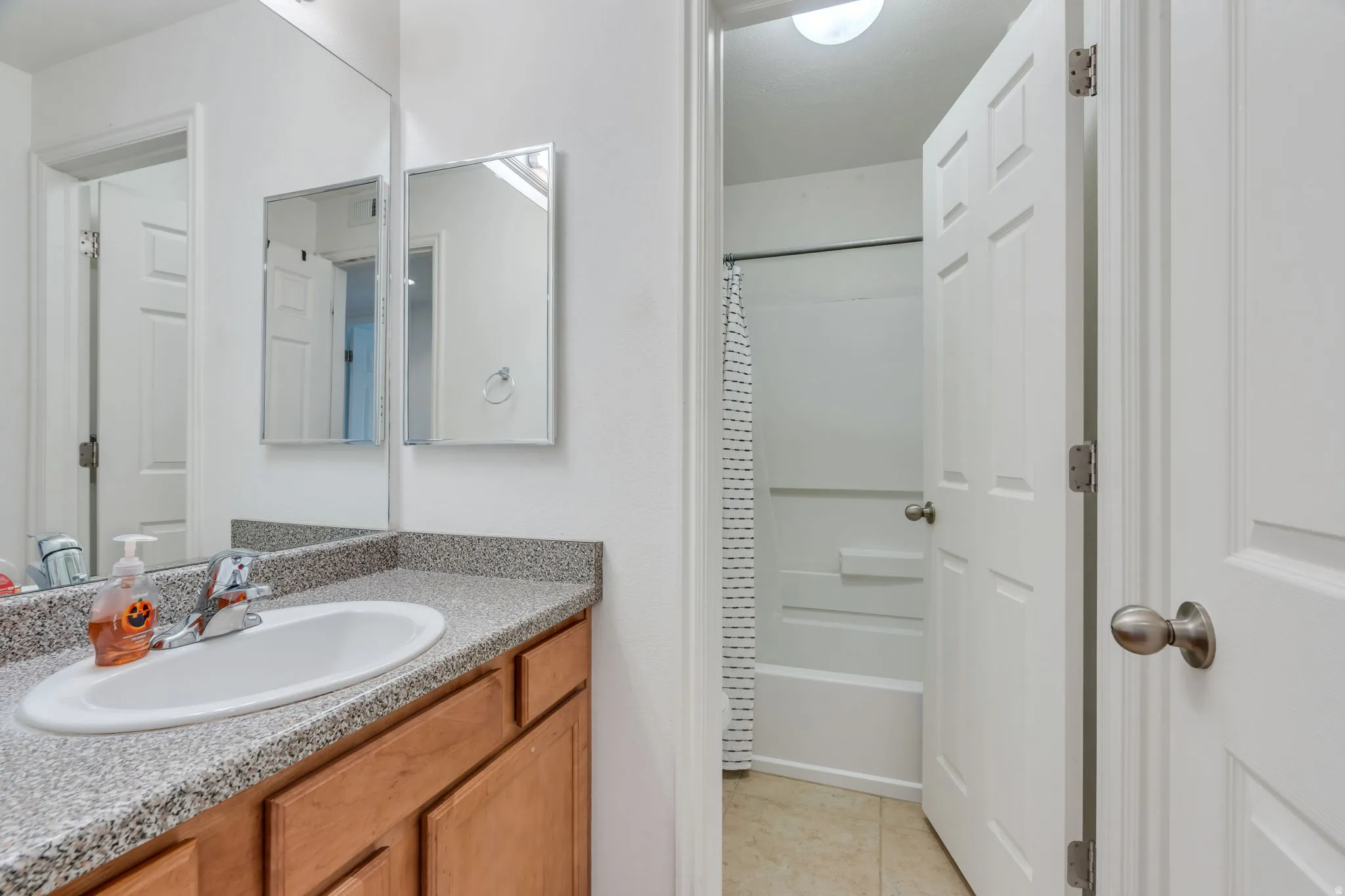 Wood-finish vanity with an integrated sink and speckle-finish countertop