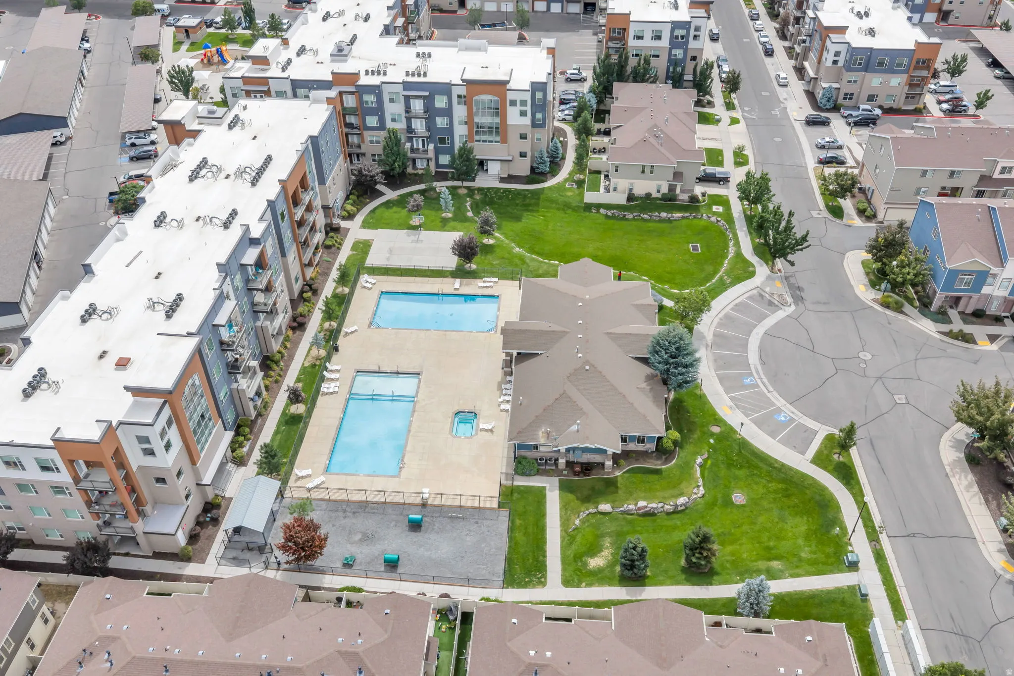 Community amenities featuring two swimming pools, a hot tub, a basketball court, and expansive green spaces