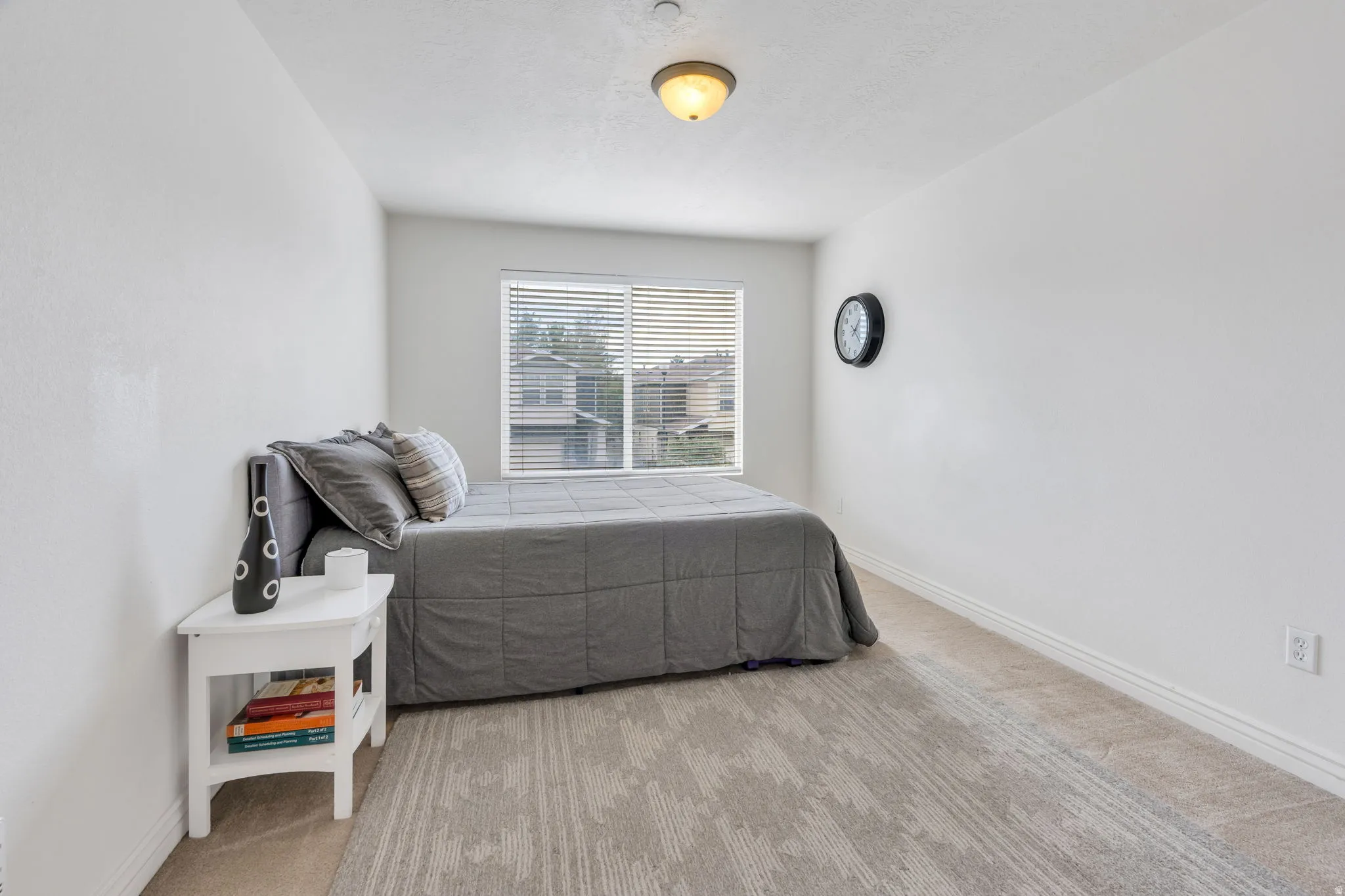 Carpeted room with a window featuring horizontal blinds