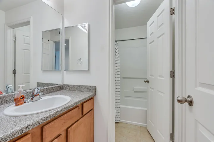 Wood-finish vanity with an integrated sink and speckle-finish countertop