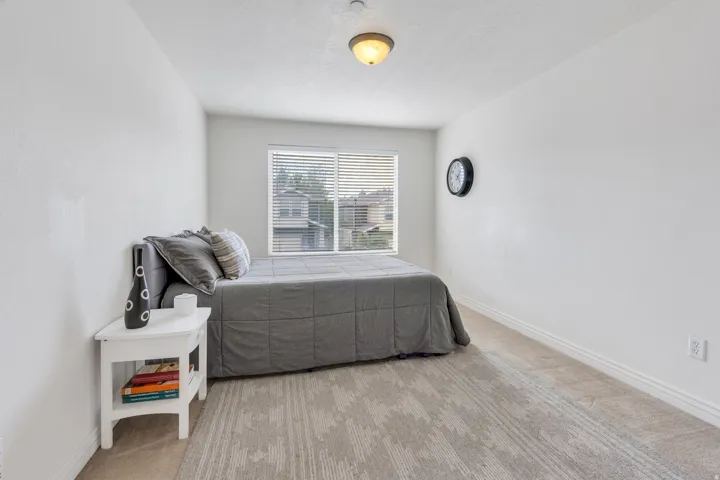 Carpeted room with a window featuring horizontal blinds