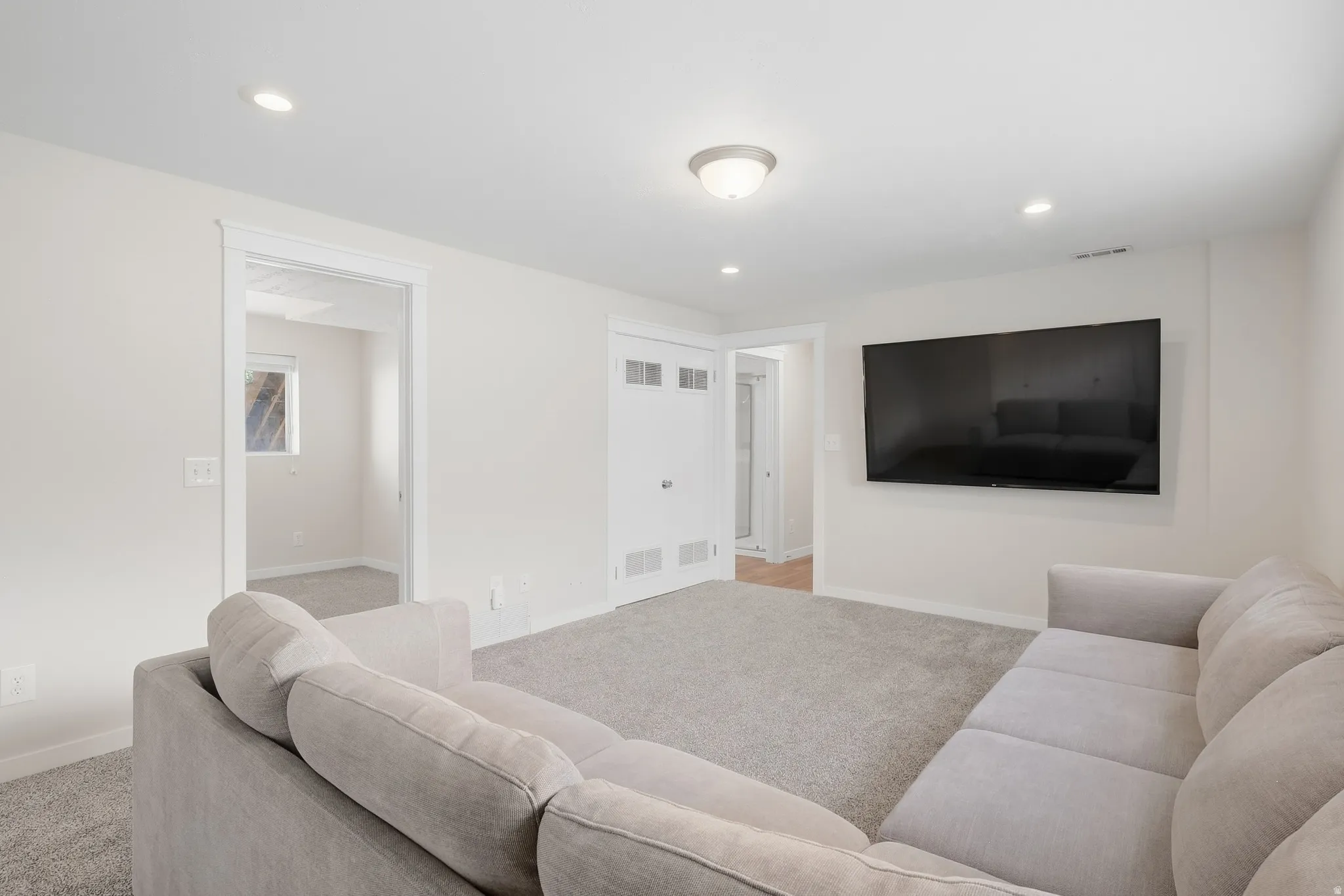 Recessed lighting and a flush-mount ceiling fixture illuminate the space