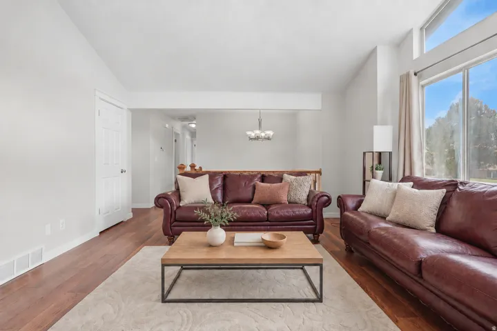 Spacious room featuring wood-finish flooring, ample natural light from large windows, and a neutral color palette