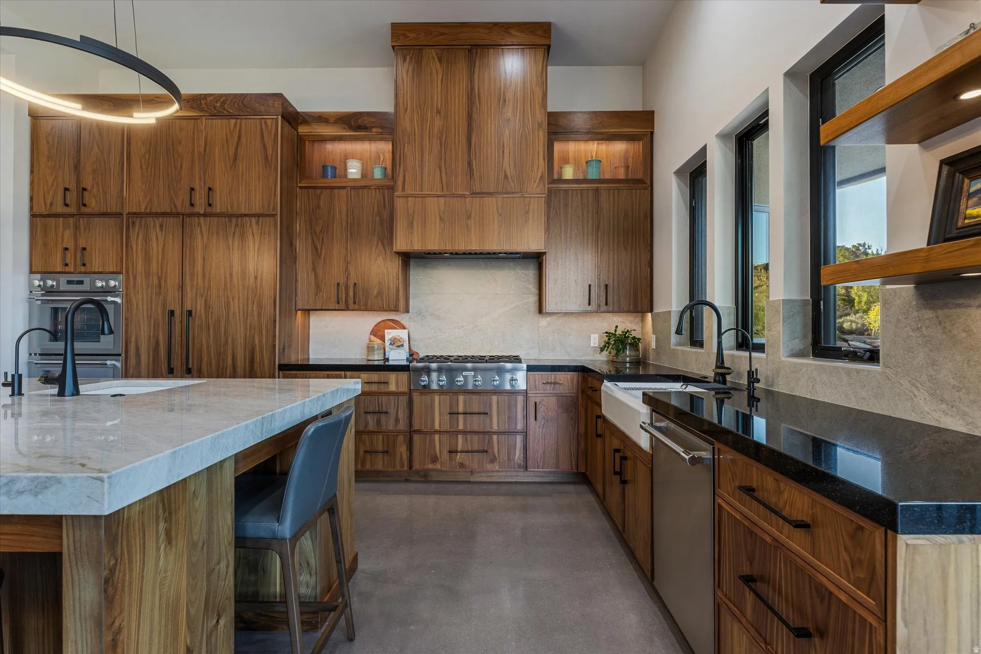 Full-height walnut cabinetry and a farmhouse sink beneath a trio of picture windows framing Mt. Kinesava.