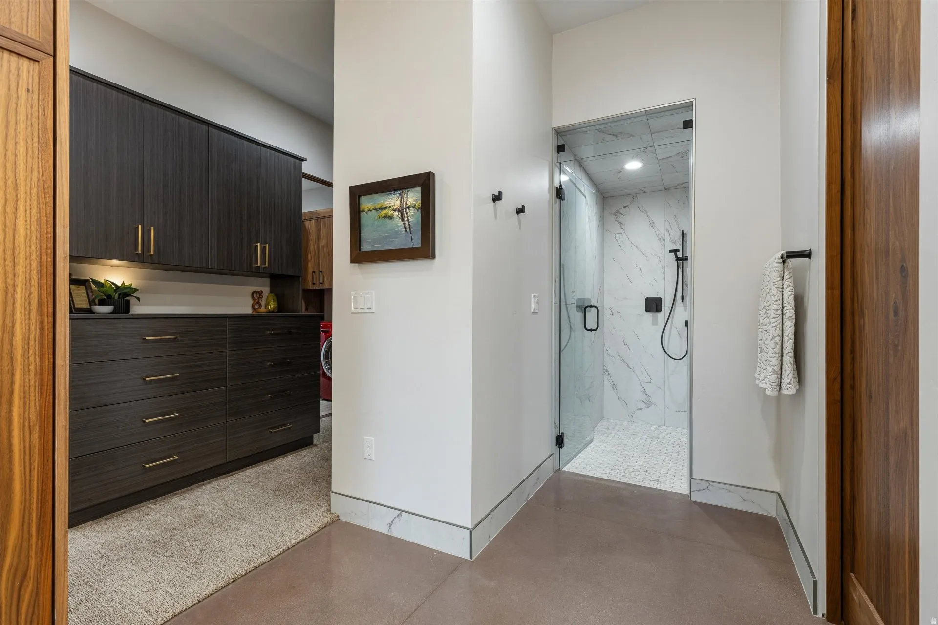 Primary bath's oversized marble-tile steam shower (Mr. Steam) with a glass swing door and built-in bench, just past the private water closet with a Toto Washlet bidet toilet.