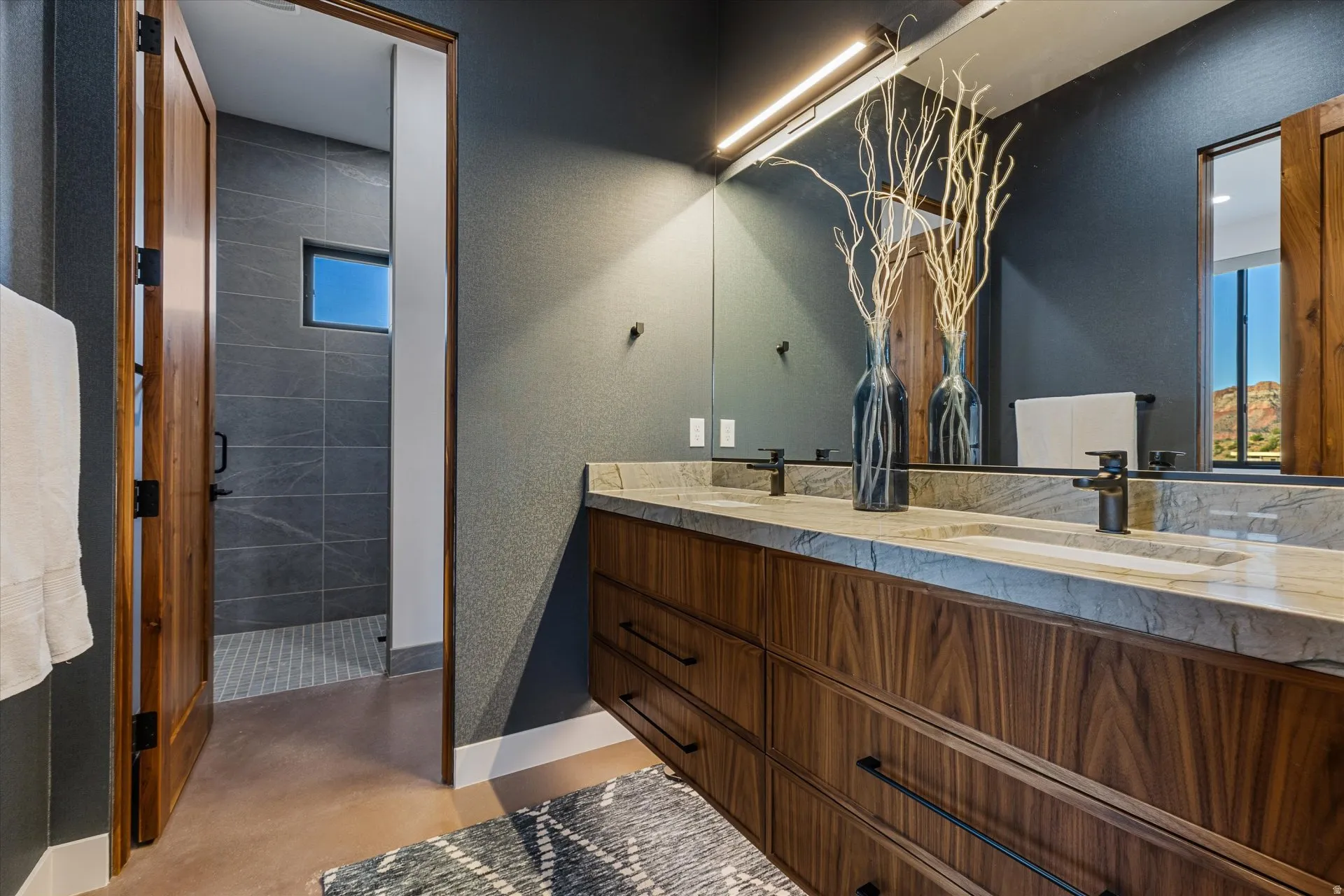 Guest bath with gorgeous countertops, an under-lit floating vanity, and textured wallpaper accents.