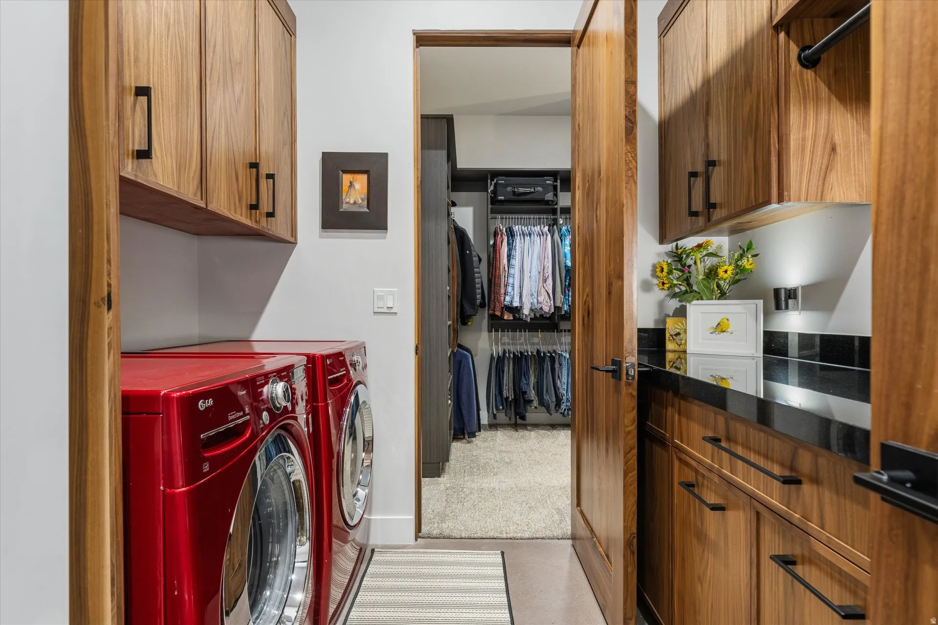 Laundry room with walnut cabinet storage. (Front-load washer/dryer convey.)
