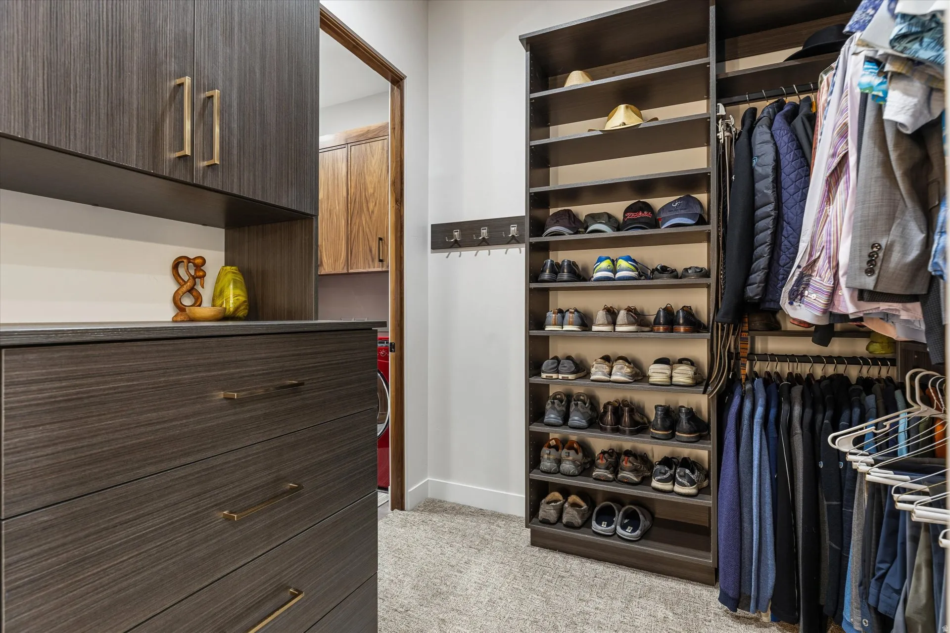 Primary closet with dresser built-ins and direct access to the laundry room.