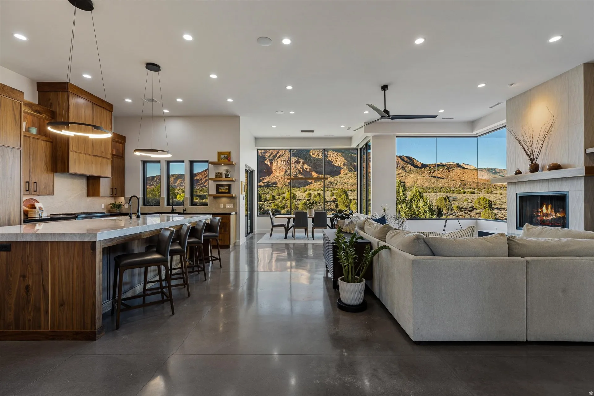 The kitchen opens directly into the living space, with a walnut feature wall and polished concrete floors.