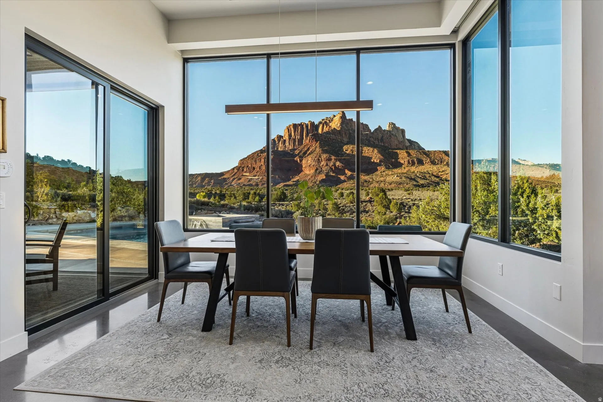 A dining space with wraparound windows turns every meal into a view of Mt. Kinesava.