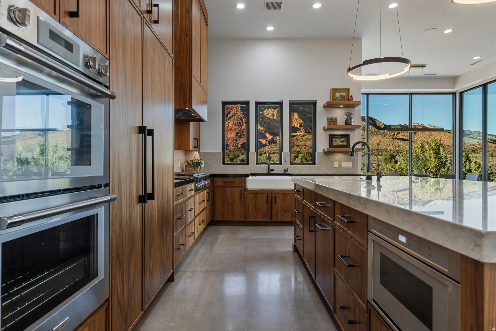 Thermador double wall ovens and a pro-style gas rangetop, set beneath a custom walnut hood, headline the kitchen.
