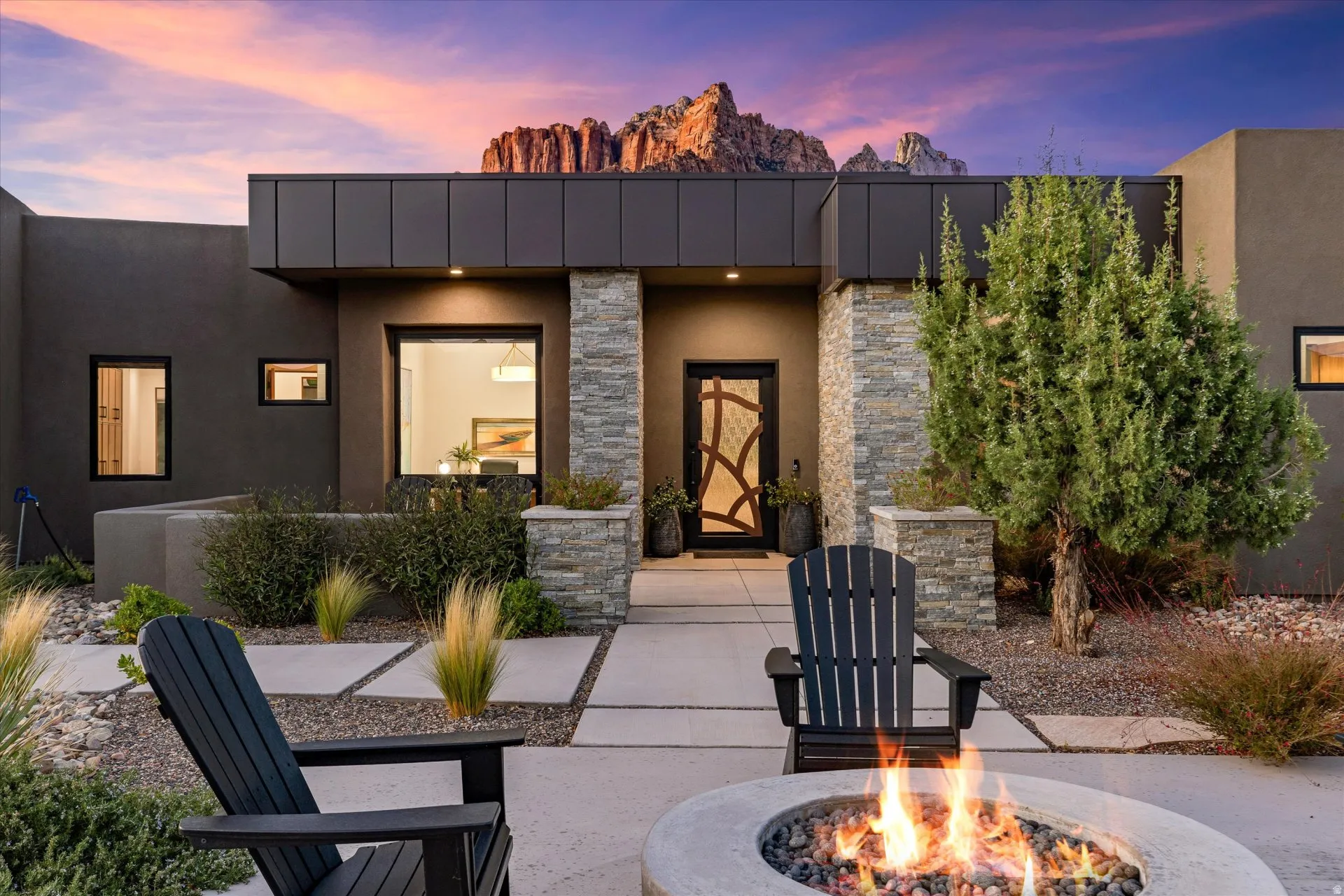 A stone-walled front patio, framed by fire and soft evening light.