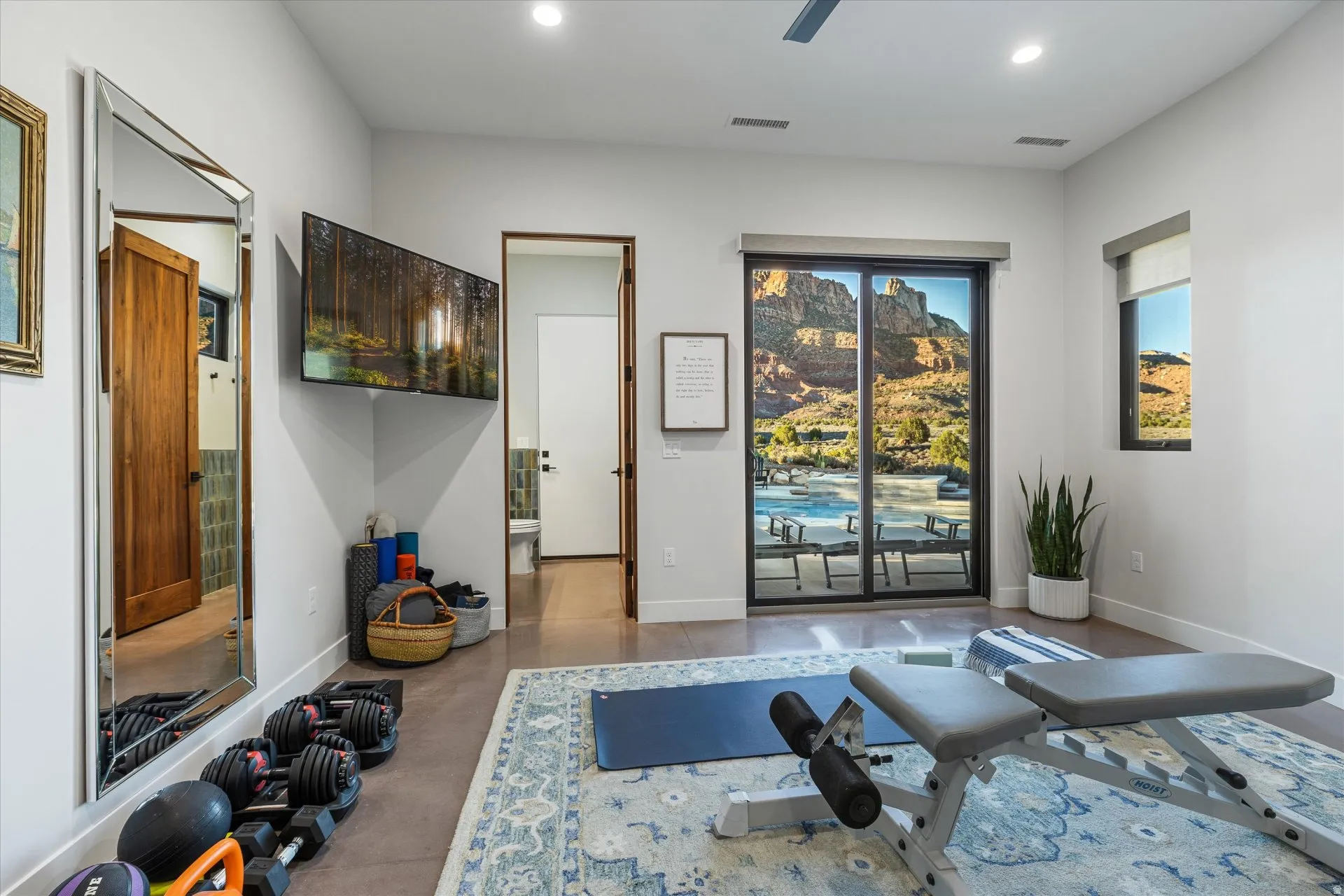 This bedroom is currently set up as a home gym, opens through a slider straight to the pool patio.