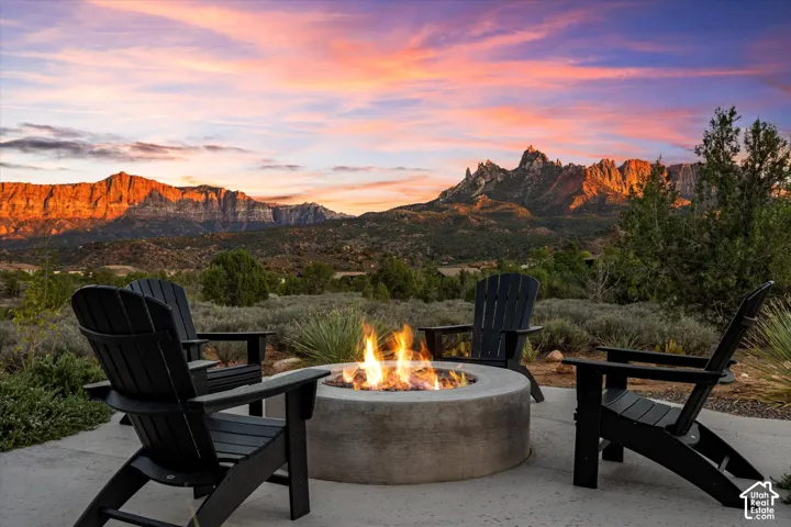 The front-yard fire pit glows as red rock silhouettes fade into the horizon.