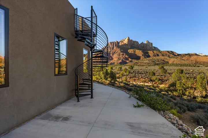 Wrought iron spiral staircase leading to the rooftop deck, Mt. Kinesava rising behind it.