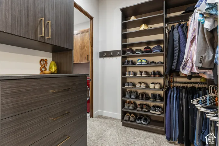Primary closet with dresser built-ins and direct access to the laundry room.