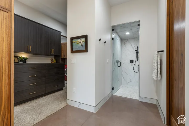 Primary bath's oversized marble-tile steam shower (Mr. Steam) with a glass swing door and built-in bench, just past the private water closet with a Toto Washlet bidet toilet.