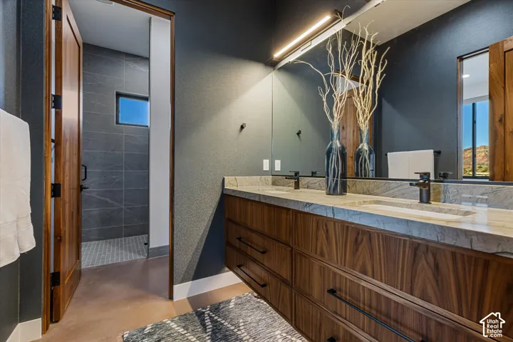 Guest bath with gorgeous countertops, an under-lit floating vanity, and textured wallpaper accents.