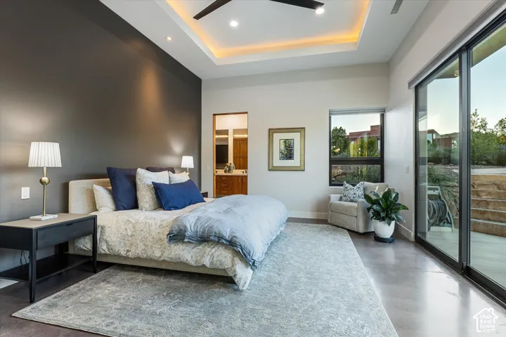 Primary suite opens to the pool patio through a slider, with a tray ceiling, fan, and direct access to a private outdoor space.