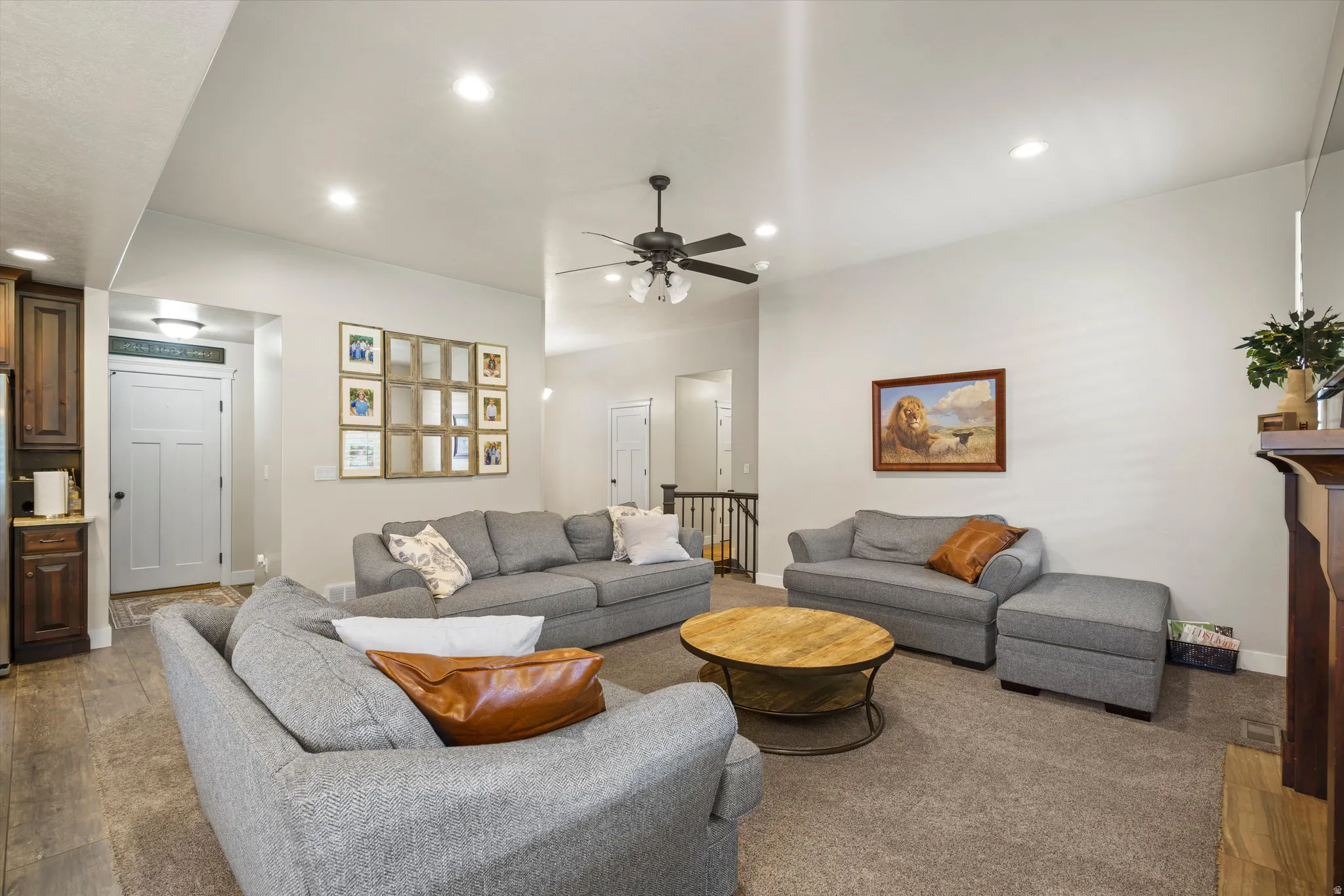 Recessed lighting, wood-finish flooring, ceiling fan, and a built-in fireplace with a mantel