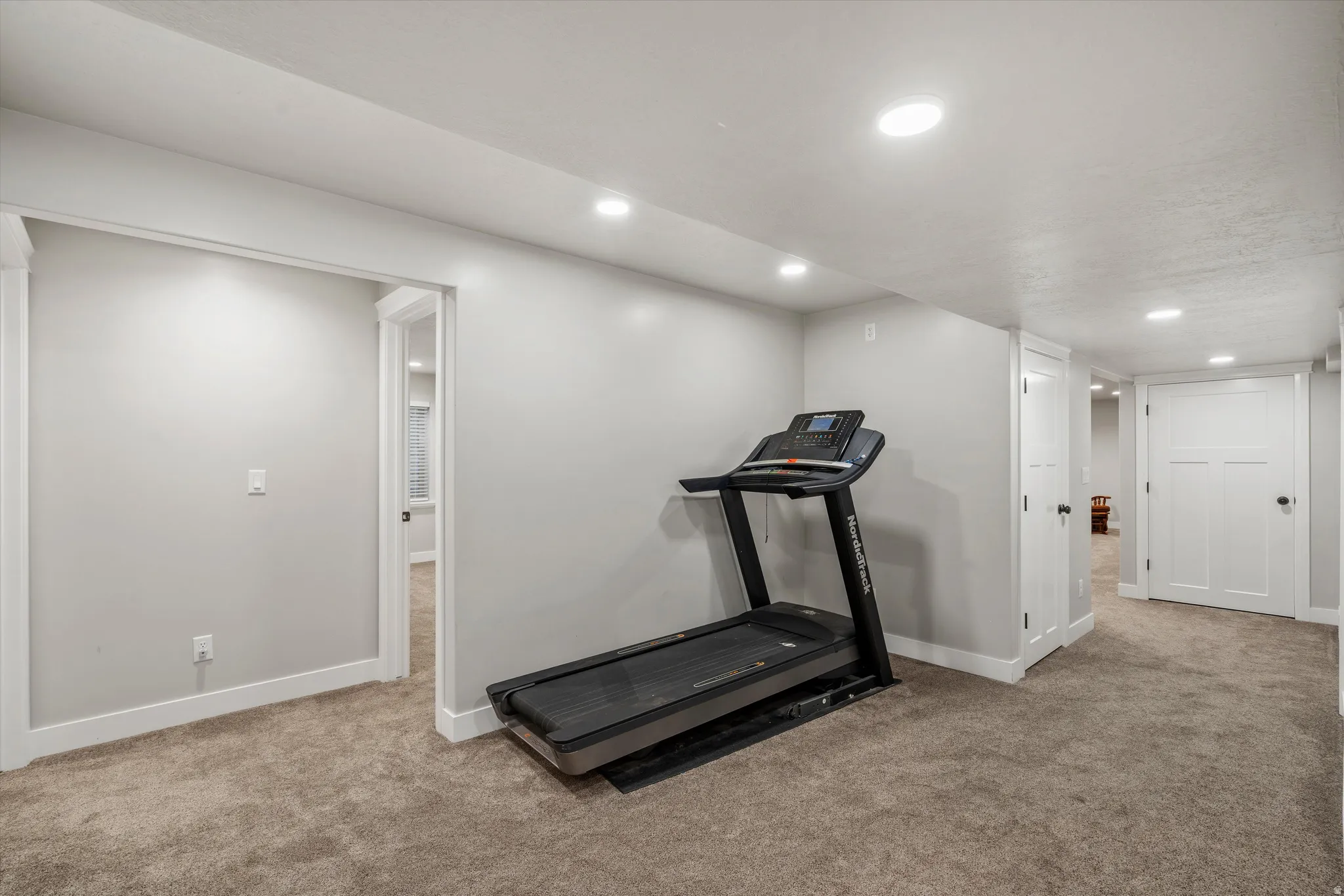 Recessed lighting, light gray walls, carpeted flooring, white trim, and white paneled doors