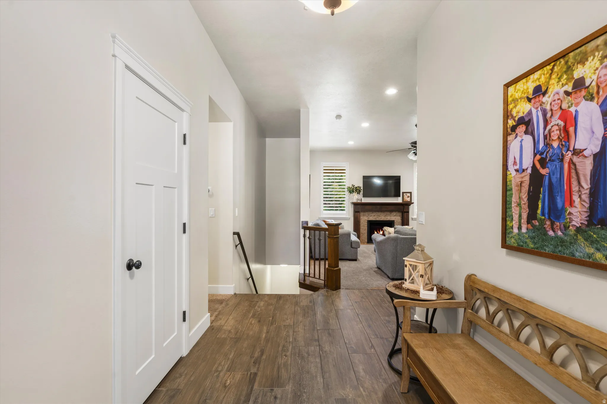 Entryway featuring wood-finish flooring, white paneled doors, and a wood staircase with dark metal railings